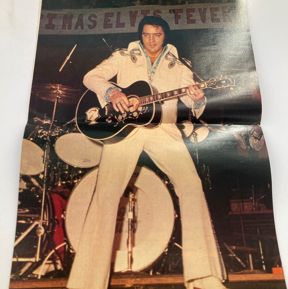 Promotional image from VTG Fall 1987 Exclusively Elvis Presley Special Collector showing Elvis Presley performing on stage with guitar, dressed in white attire.