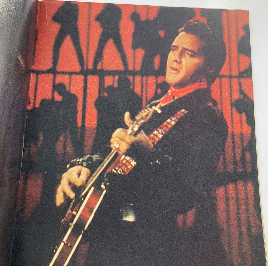 Photo page from VTG Ideal's Celebrity Series August 1979 Elvis Presley Remembered magazine featuring Elvis Presley performing on stage with a vibrant red background.
