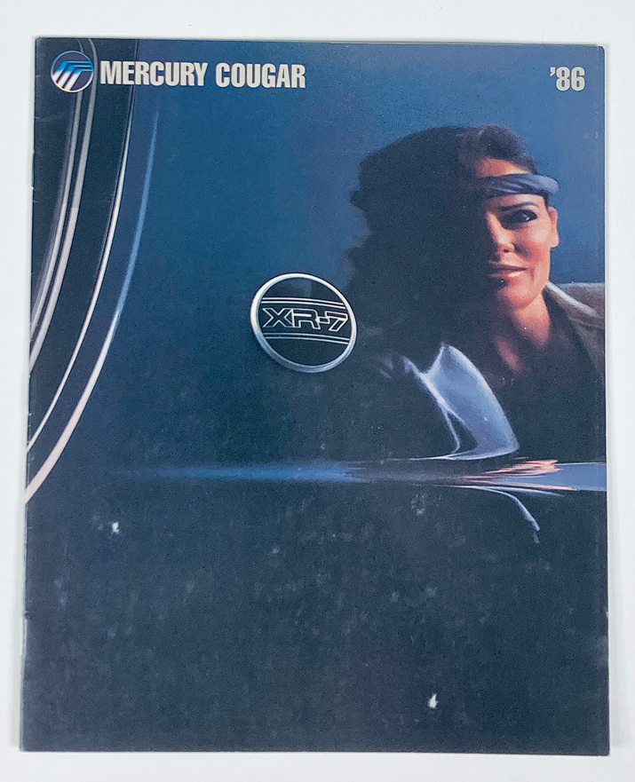1986 Mercury Cougar Dealer Showroom Sales Brochure Cover featuring an artistic design with a woman, showcasing the Cougar XR7 model.
