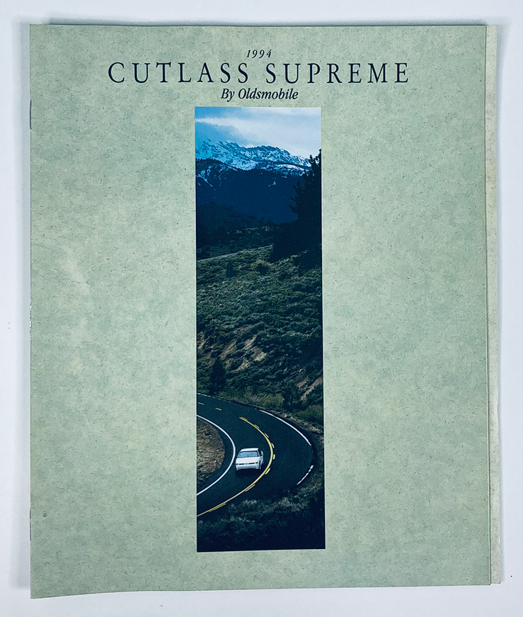 1994 Oldsmobile Cutlass Supreme Dealer Showroom Sales Brochure featuring a scenic road with the car, showcasing the design and aesthetic of the Cutlass Supreme.