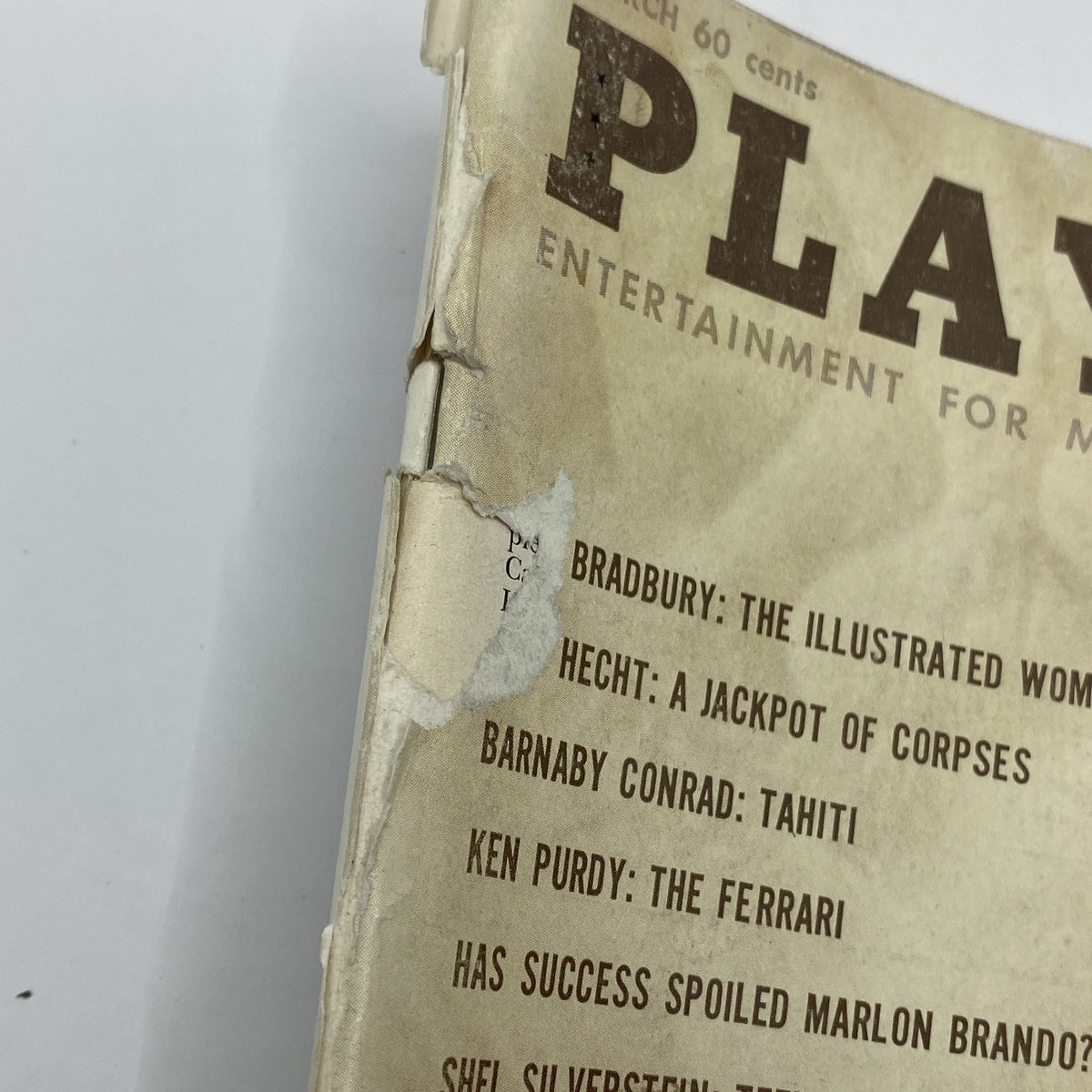 Close-up of the cover of VTG Playboy Magazine March 1961, highlighting minor wear and tear, emphasizing its vintage nature and collectible status.