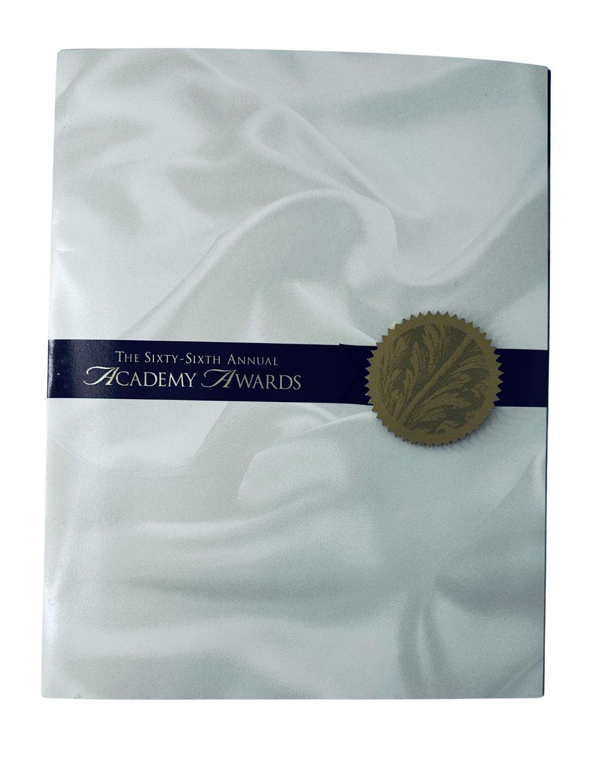 Cover of the 'Oscars 66th Annual Academy Awards 1994 Program Magazine' featuring elegant white satin and a gold seal.