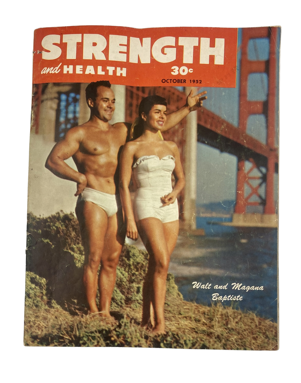 Strength and Health Magazine October 1952 cover featuring Walt and Magana Baptiste by the Golden Gate Bridge, showcasing the charm of vintage fitness culture.