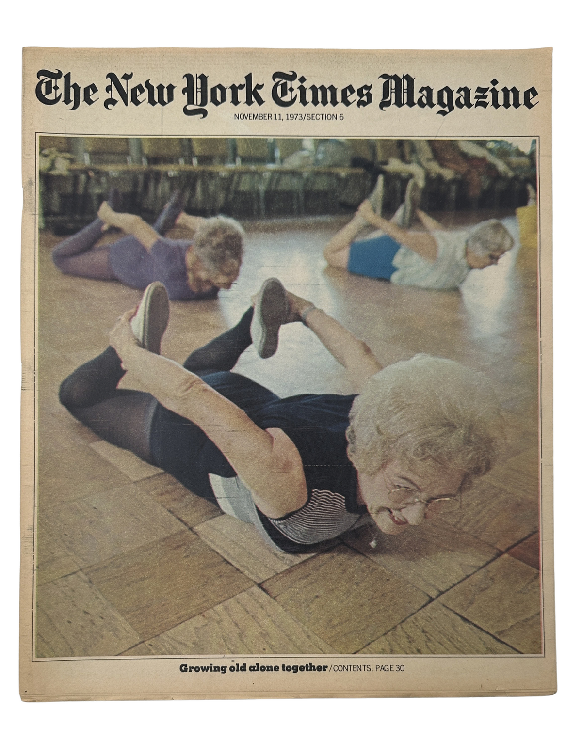 The New York Times Magazine cover from November 11, 1973, featuring elderly women participating in an exercise class at a California retirement community, titled 'Growing Old Alone Together.' The image illustrates a new lifestyle for the elderly with emphasis on community activities.