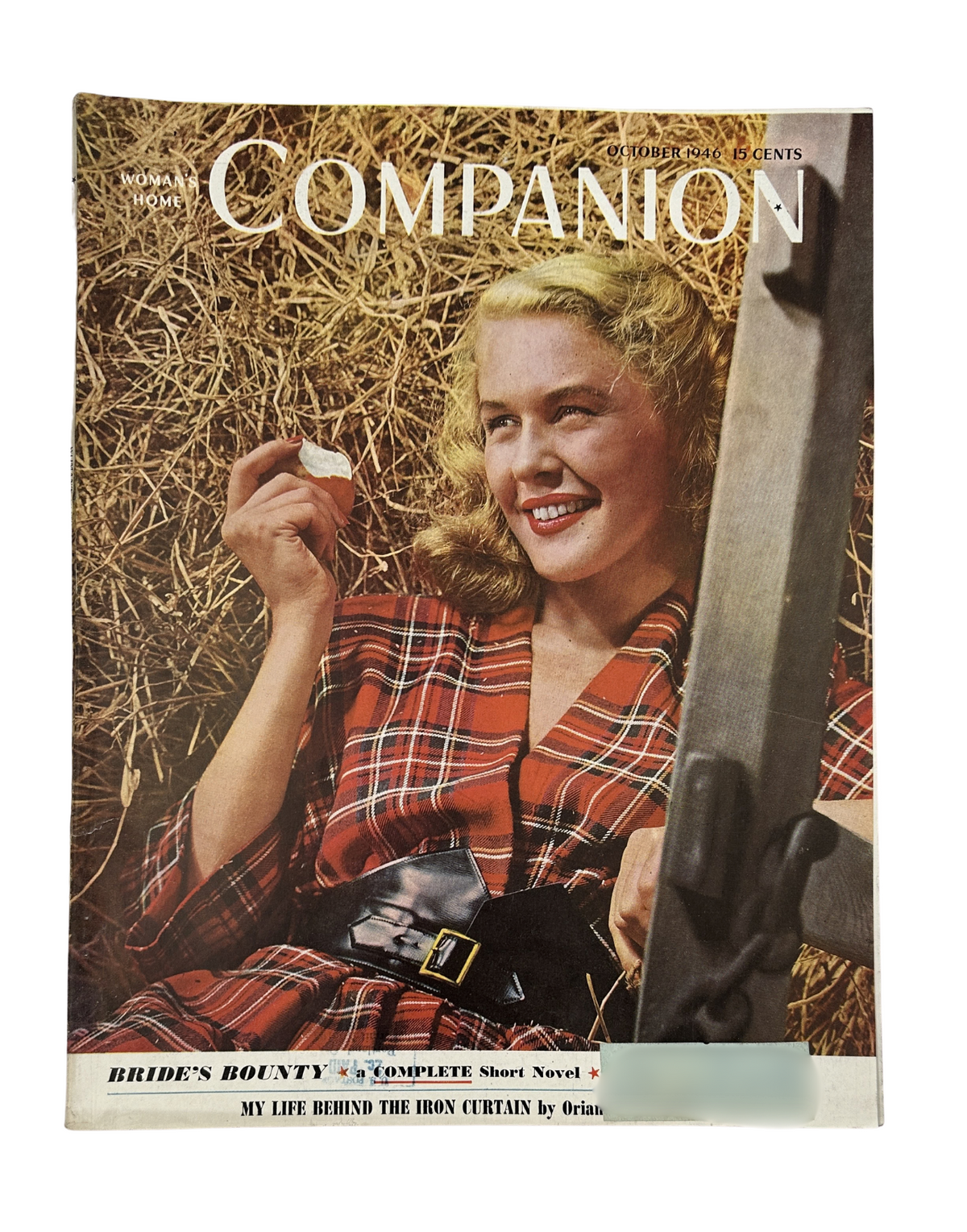 Cover of Woman's Home Companion Magazine from October 1946 featuring the short novel 'Bride's Bounty'. The cover image shows a smiling woman in a plaid dress sitting on hay, holding a small item.