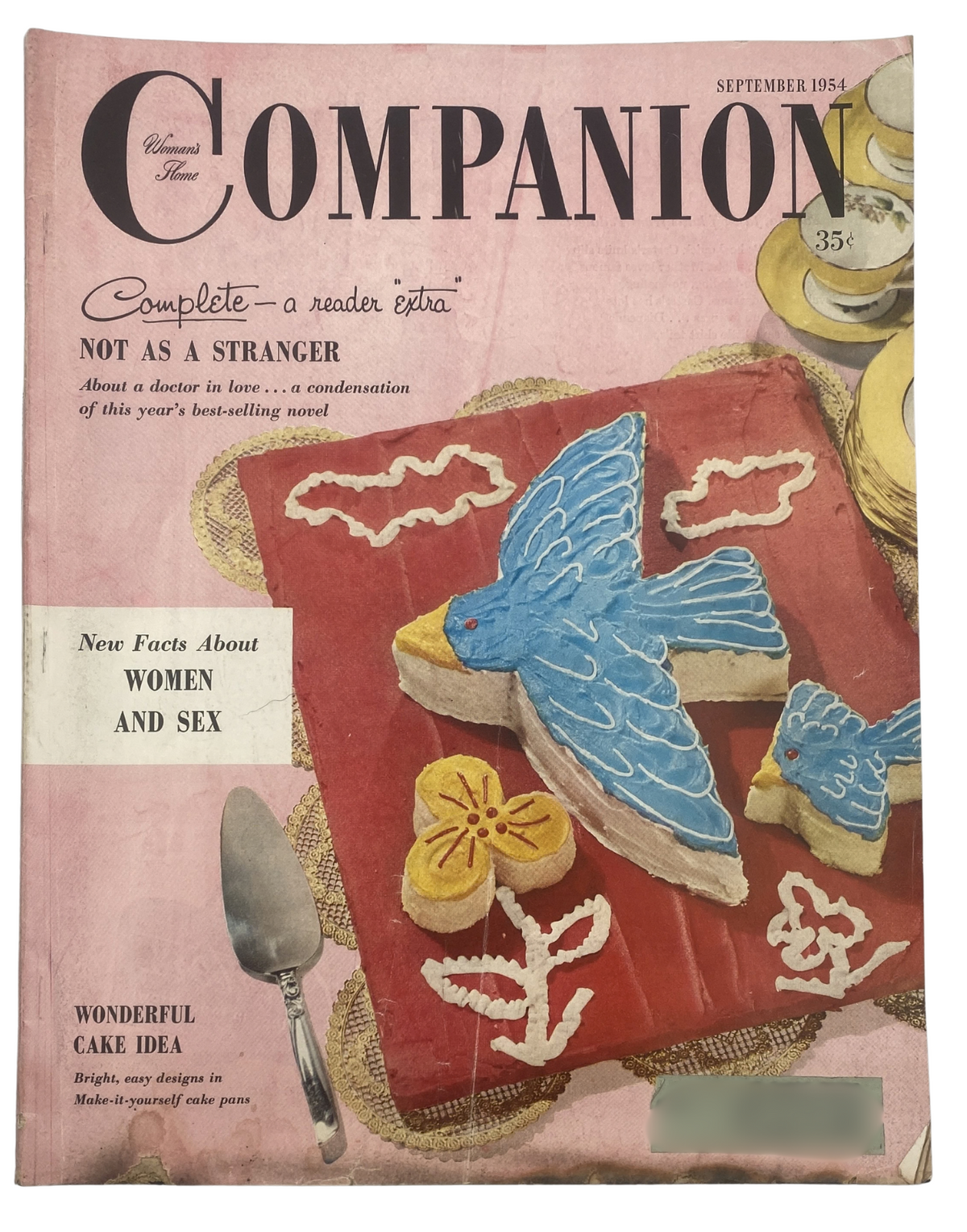 Cover of Woman’s Home Companion Magazine September 1954 featuring a colorful cake design, a blue bird decoration, and the headline 'Not As a Stranger' with a focus on women and sex.