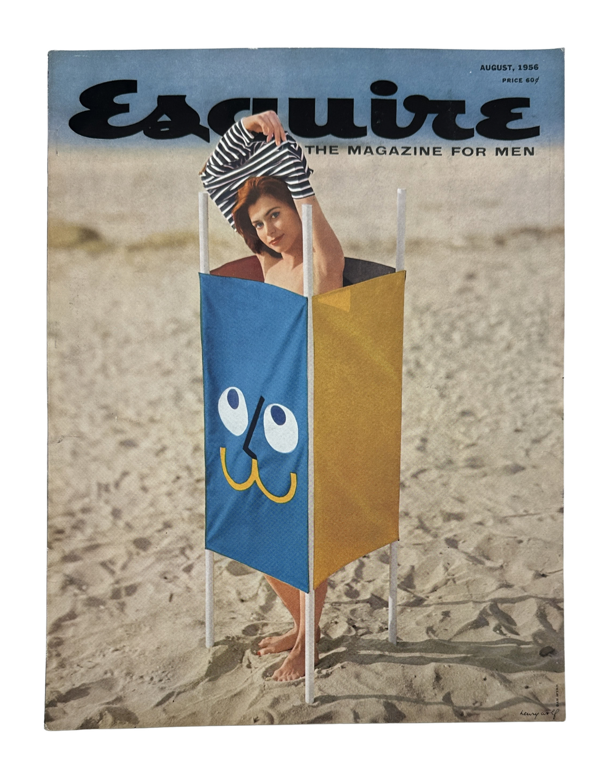 Esquire Magazine August 1956 cover featuring a playful beach scene with a girl peeking out from a colorful pinup display.