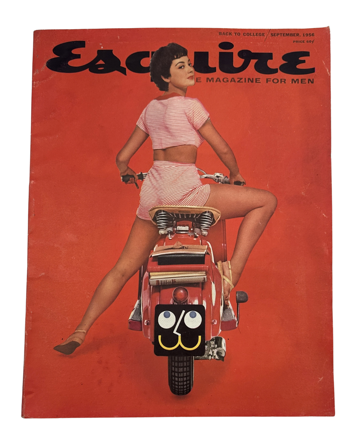 Cover of Esquire Magazine September 1956 featuring a woman in a pink outfit riding a scooter, with a whimsical expression, emphasizing college themes.