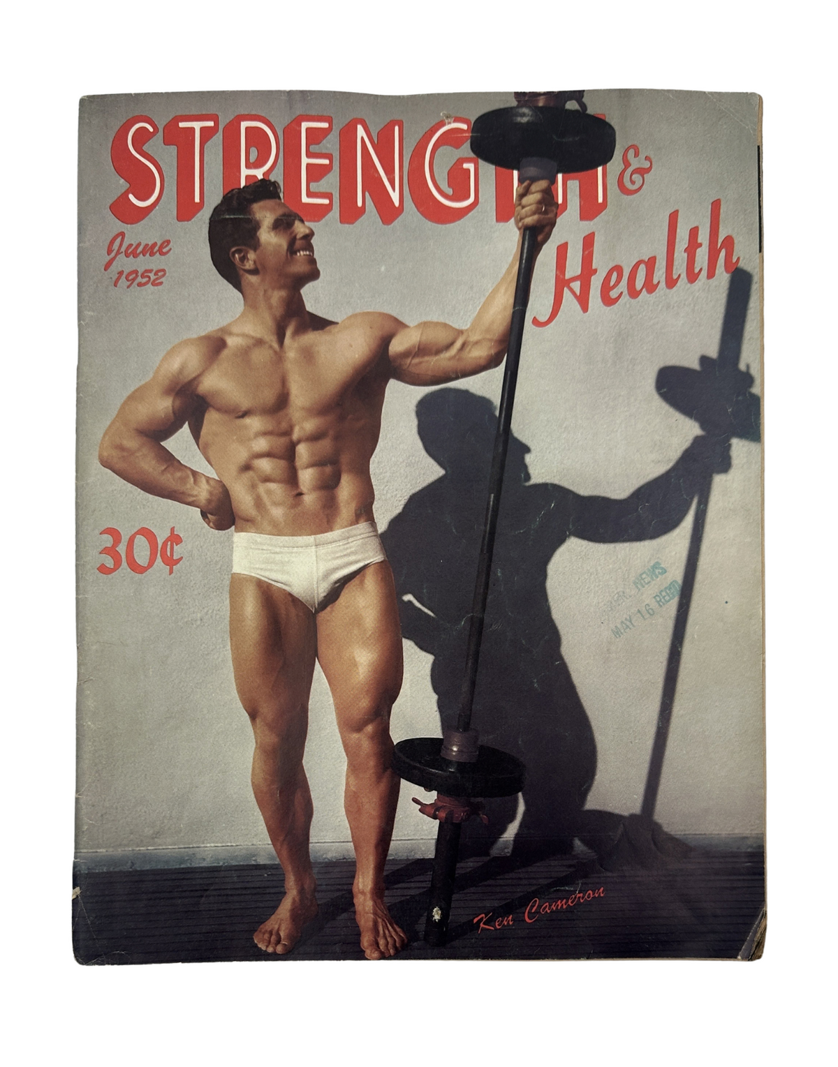 Cover of Strength and Health Magazine from June 1952 featuring Ken Cameron, showcasing a muscular man posing with a dumbbell against a backdrop with his shadow.