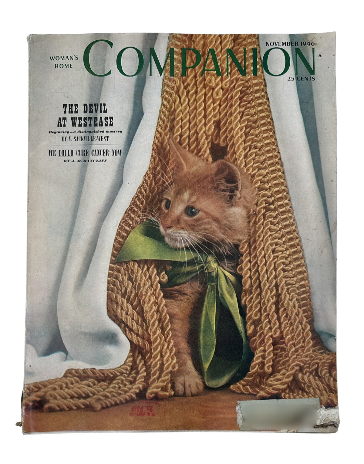 Cover of Woman’s Home Companion Magazine November 1946 featuring a cat peeking out from behind a knitted backdrop, promoting the story 'The Devil at Westease' by V. Sackville-West.