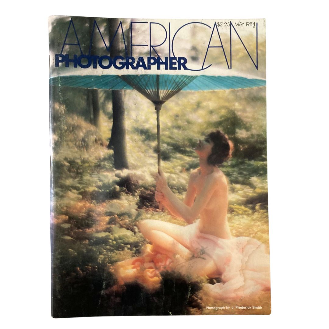 Cover of American Photographer Magazine, May 1984, featuring artistic photography by J. Frederick Smith and the iconic Betty Biehn, showcasing vibrant colors and a model with an umbrella in a scenic setting.