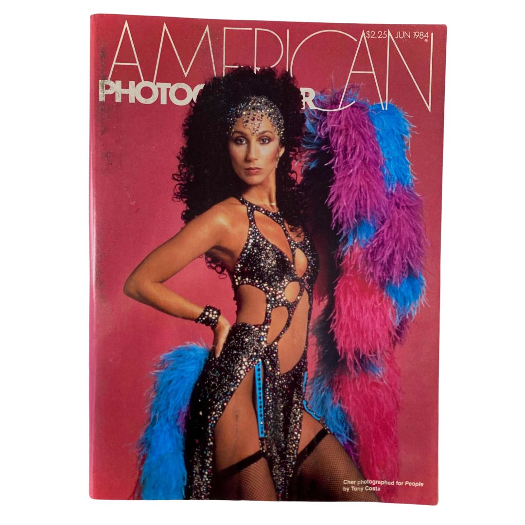 American Photographer Magazine June 1984 Cover featuring an iconic photograph of Cher, showcasing her in a glittering outfit and vibrant feather boas.