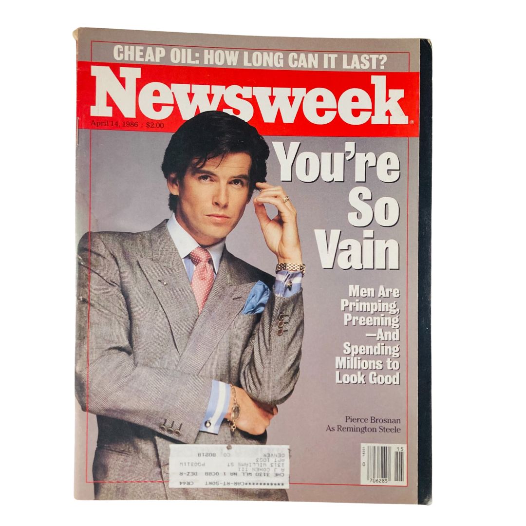 Vintage Newsweek magazine cover from April 14, 1986 featuring Pierce Brosnan as Remington Steele, showcasing a stylish man in a gray suit with a bowtie and pink shirt against a bold red background.